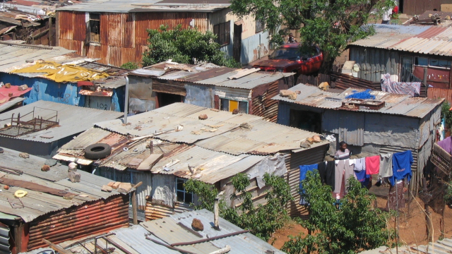 Des millions de sud-africains n'ont pas accès à la terre. L'unique choix qui s'offre à eux est de se masser dans des townships, condamnés à travailler comme ouvrier dans les usines, les mines ou les fermes détenues par une minorité de riches noirs ou blan Des millions de sud-africains n'ont pas accès à la terre. L'unique choix qui s'offre à eux est de se masser dans des townships, condamnés à travailler comme ouvrier dans les usines, les mines ou les fermes détenues par une minorité de riches noirs ou blan